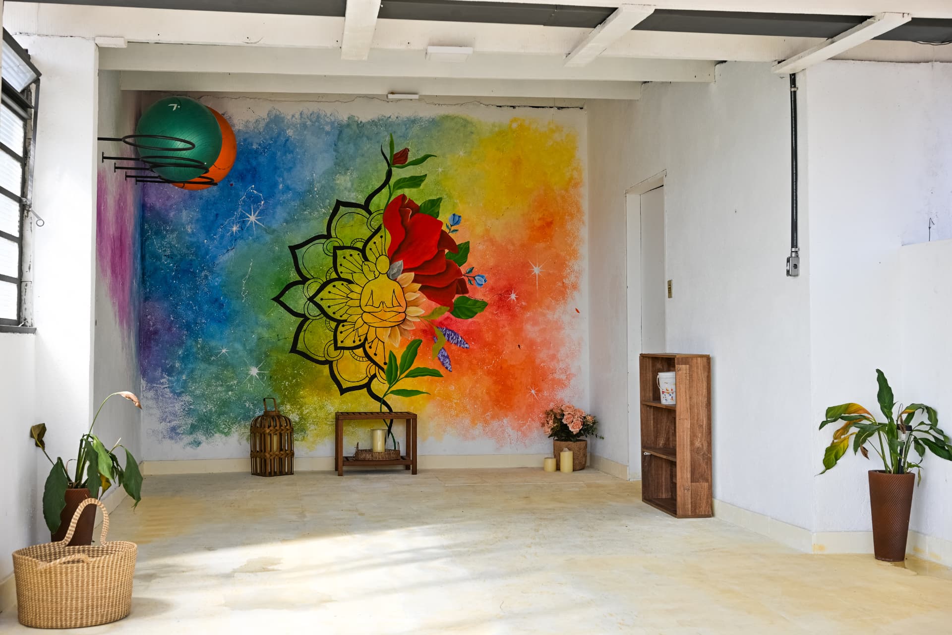 Salão amplo do studio com mural colorido e plantas